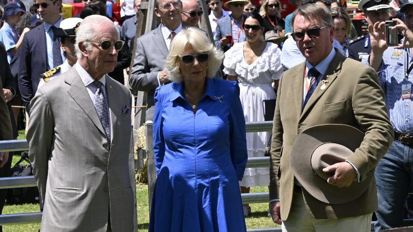Prince Charles III and Queen Camilla with a distinguished guest during an outdoor visit at the Sydney Royal Easter Show.