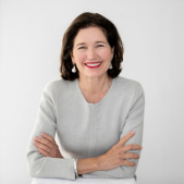 Headshot of Pig and Alpaca Committee Chair Janie Forrest smiling with crossed arms and wearing a light grey top.