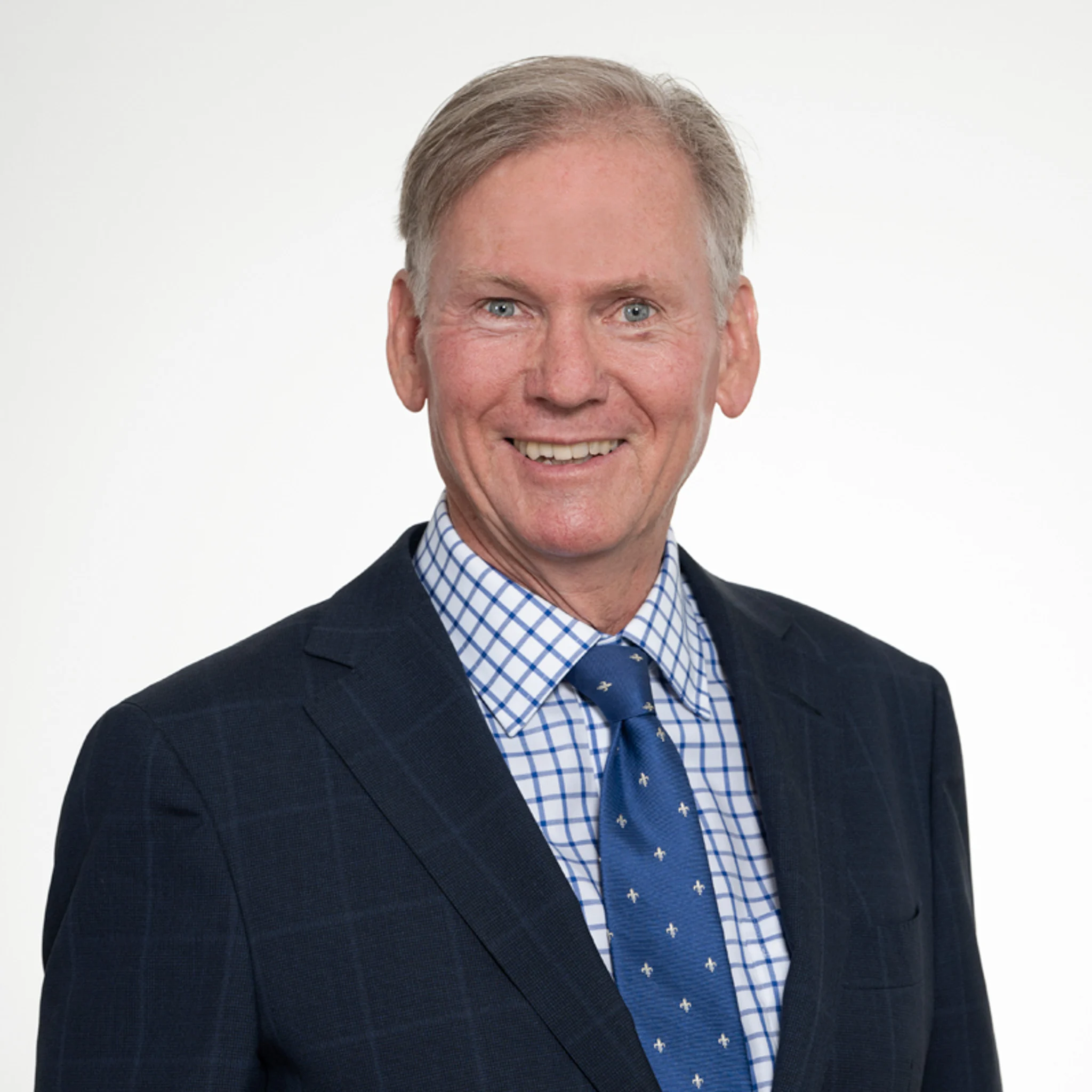 Headshot of Vice President and Board Member David Davison, smiling and wearing a dark suit, blue tie, and checkered shirt.
