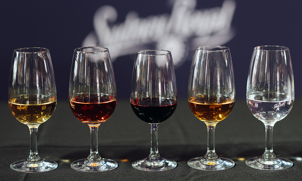 Five glasses of spirits in varying colours lined up for the Sydney Royal Distilled Spirits Show.