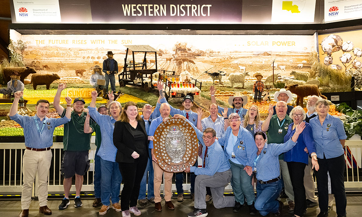 Western District Exhibitors holding large award shield in front of their produce display for the Sydney Royal District Exhibits.