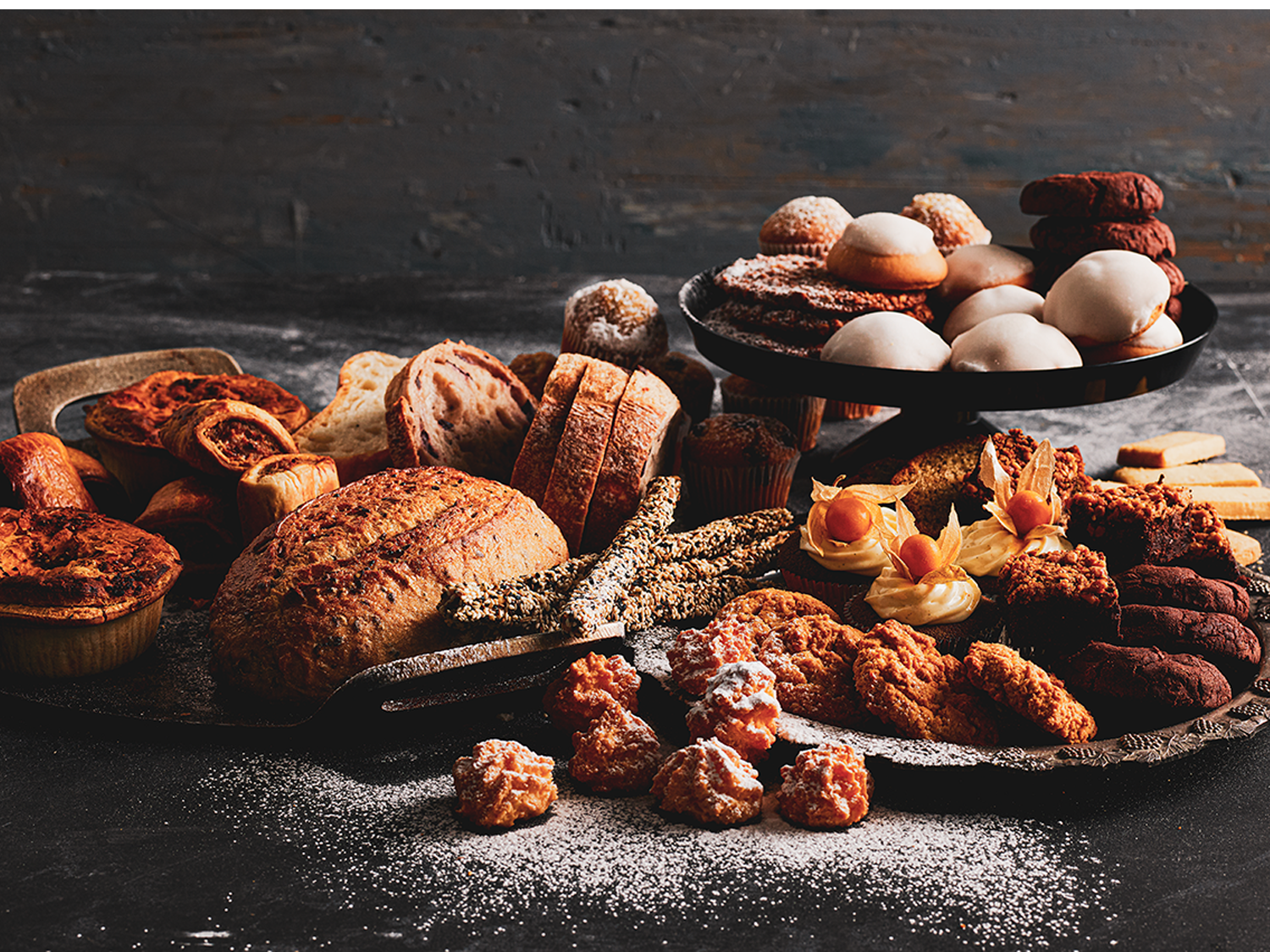 Assorted artisan breads, pastries, and biscuits arranged on dark trays for the Sydney Royal Fine Food Show Professional Bakery Competition.