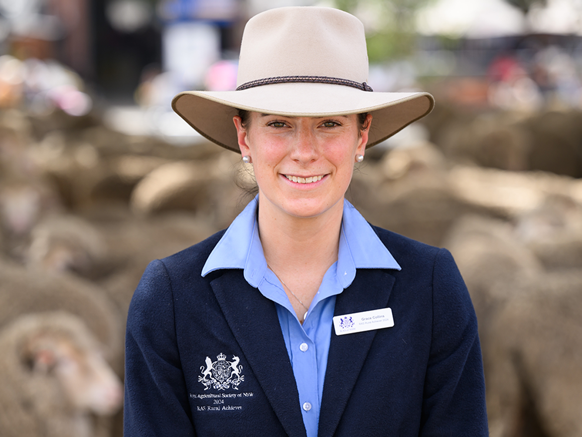 Headshot of Grace Collins, a woman with brown hair smiling in a suit and hat, winner of the 2025 RAS Rural Achiever Award.