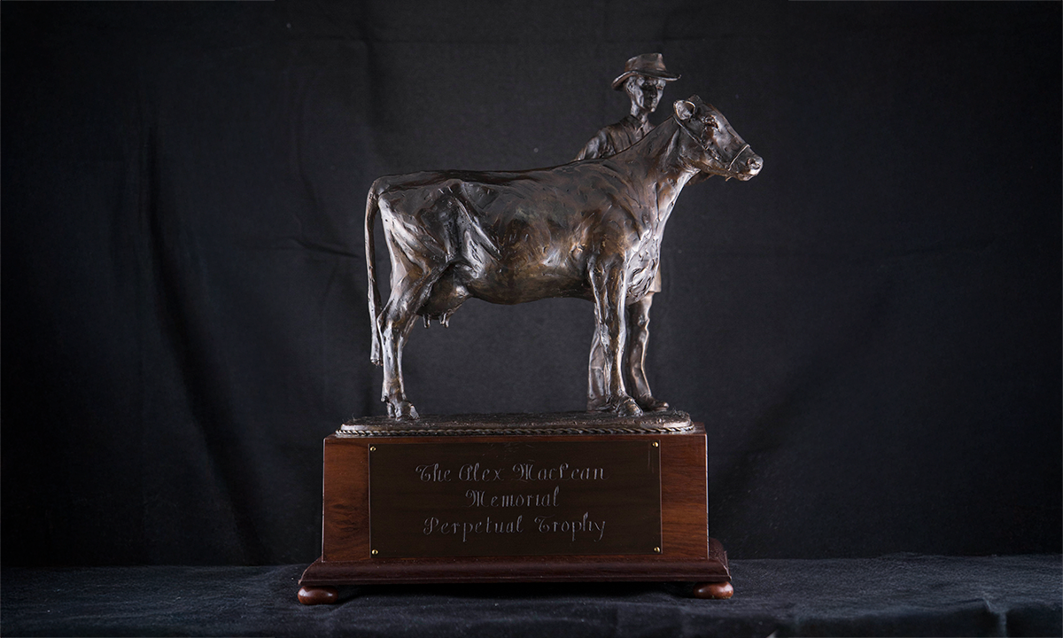 Figurine of a bronze cow and handler on a wooden base. First awarded in 2011.