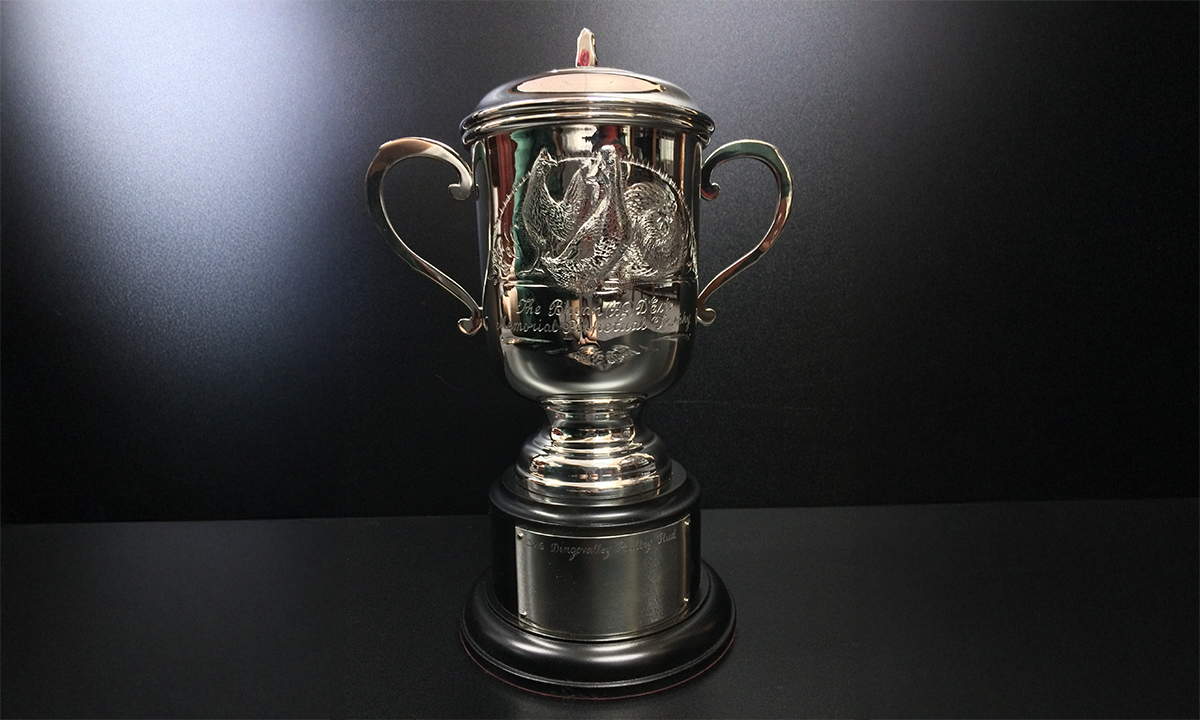 Twin handled lidded silver cup that features hand chased images of a Cuckoo Pekin Bantam, Pekin Drake and Pile Old English Game Bantam. The cup is mounted on a circular black base fitted with engraving plates. First awarded in 2016. 
