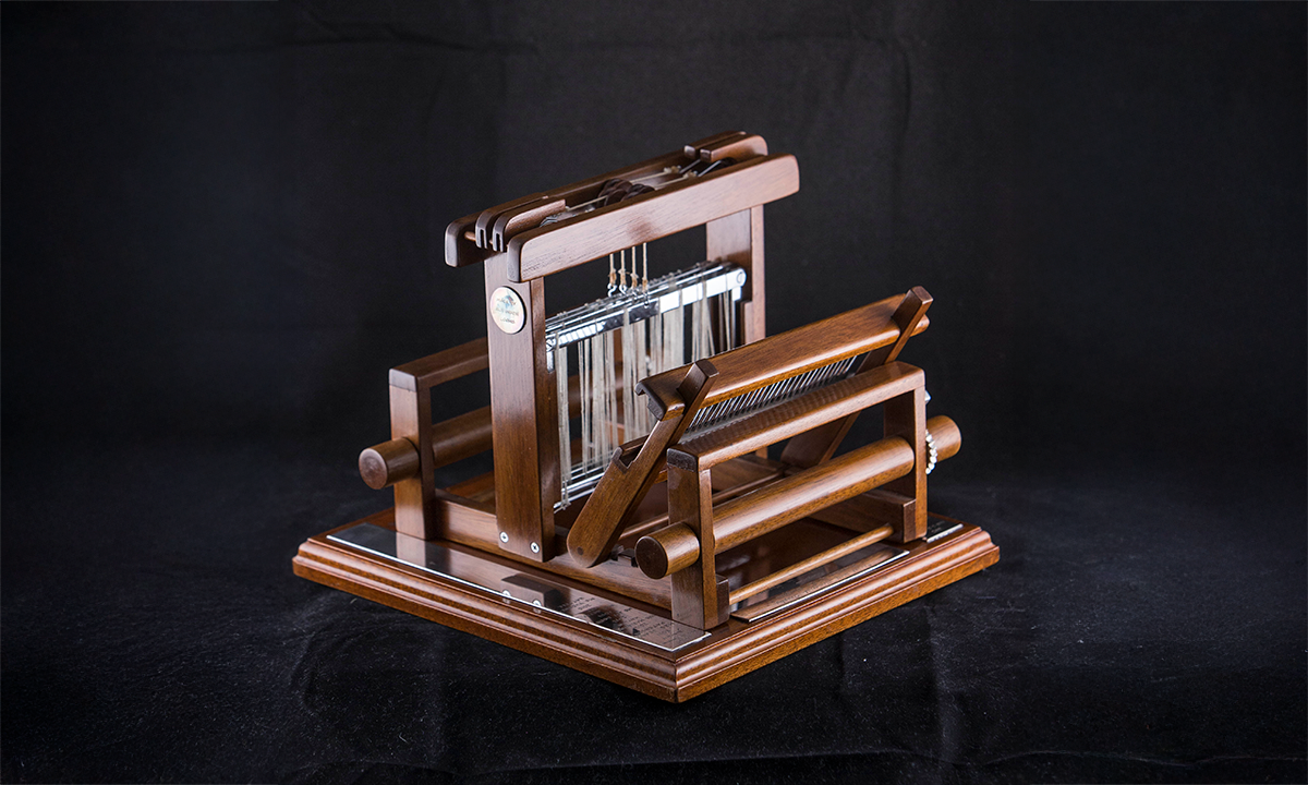 A small walnut loom with silver finishings, inscribed 