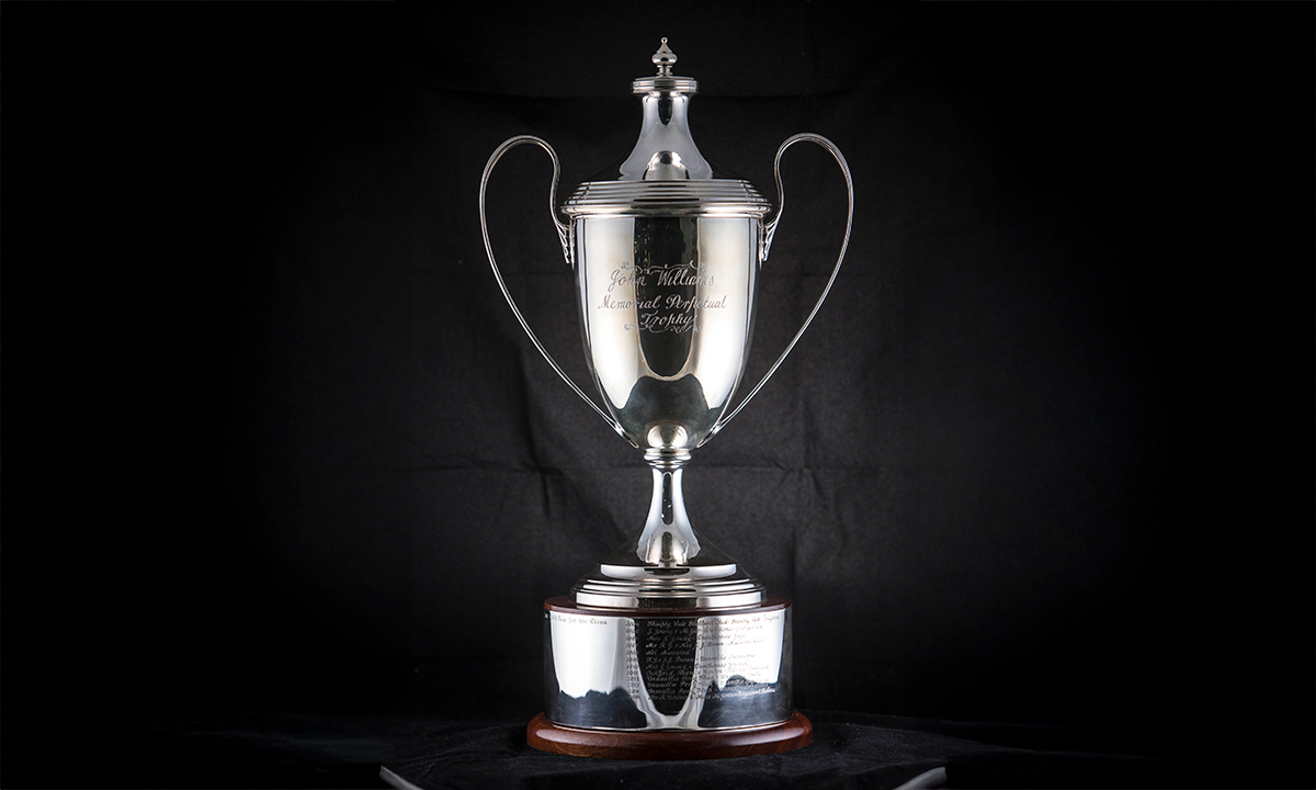 Tall twin handled trophy cup with a cover and finial, mounted on a wooden base. First awarded in 2003.