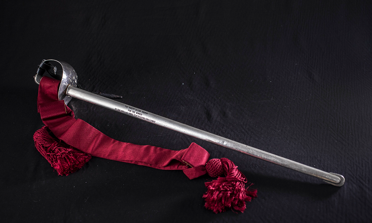 Basket handled steel sword with a red ribbon attached.  First awarded in 2000.