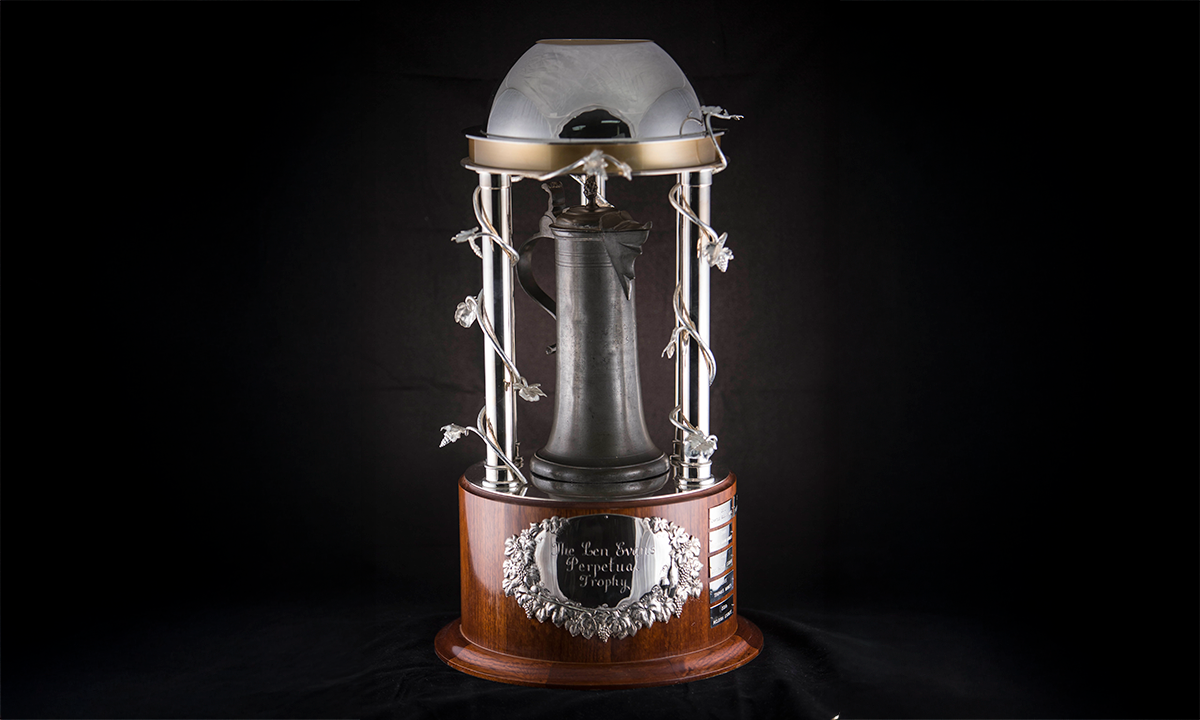 Pewter jug sits within a highly decorated silver structure, composed of 5 columns supporting a domed cover. The whole trophy is mounted on top of a round wooden base. First awarded in 2010.