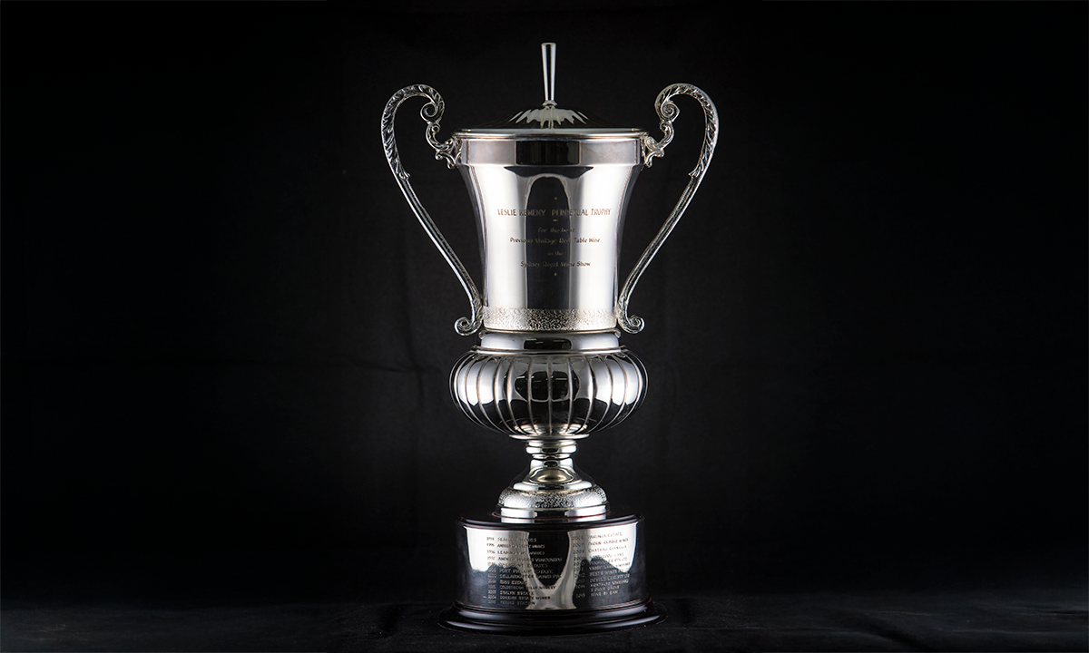 Silver cup with two scroll handles, spire lid, and a blackened timber base. First awarded in 1994.