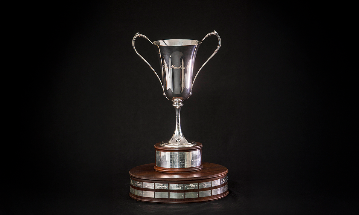 Silver cup of twin handled flared form, raised on a two-tier timber plinth. First presented in 1996.
