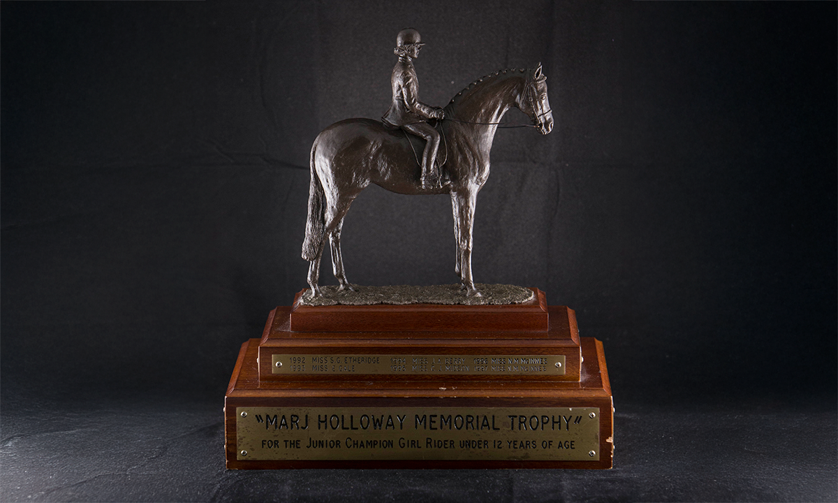 Bronze figure of a female rider seated upon a horse, raised on a tiered plinth base. First presented in 1992.