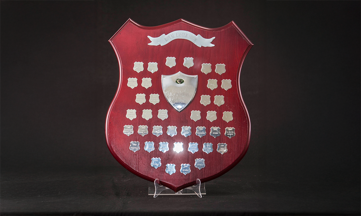 Shield with a rosewood finish and applied silver presentation shields, the centre shield with a green enamelled Suffolk sheep medallion. First awarded in 1988.
