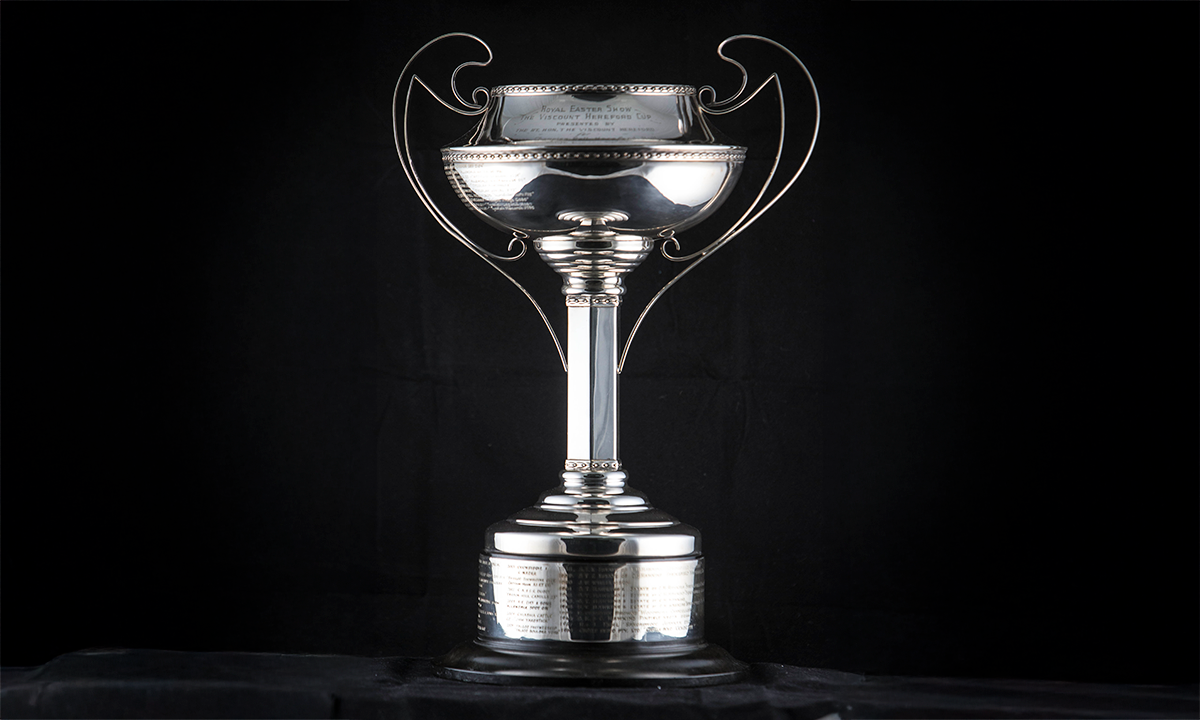 Silver handled trophy cup with a leaf and berry cast border, on a hexagonal stem, raised on a circular plinth. First presented in 1958.