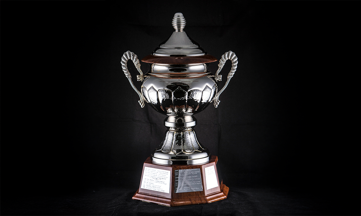 Silver twin-handled trophy cup with a domed lid, raised on an octagonal wooden base. First awarded 1992.