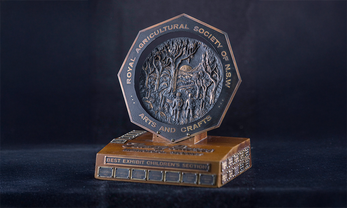 Brass octagonal plate mounted on a timber plinth, engraved 