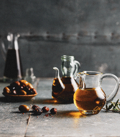 Glass jugs of olive oil with olives on display at the Sydney Royal Fine Food Show's Oil & Olives Competition.