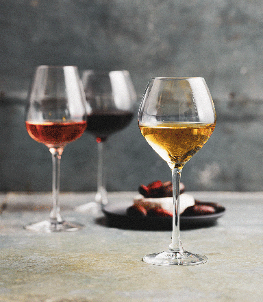 Three glasses of white, rosé, and red wine with cheese and olives in background at the Sydney Royal Wine Show.